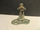 a silver figurine of a woman holding a flower
