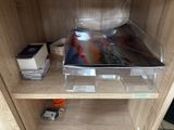 a clear shelf with magazines and other items on it