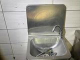 a metal sink in a bathroom with a metal faucet