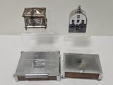 a small silver clock and a small silver box on a table