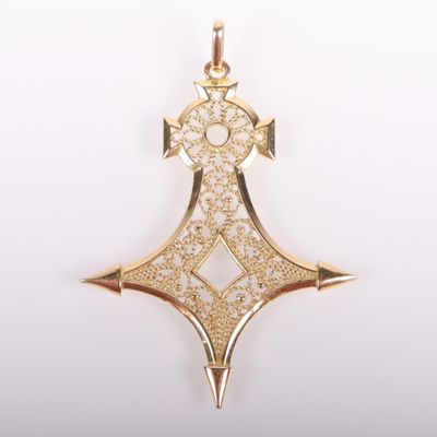 a close up of a gold pendant on a white background
