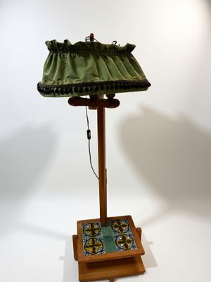 une lampe posée sur un pied en bois et dotée d'un abat-jour vert