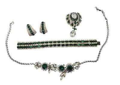 un gros plan d'un collier, d'un bracelet et de boucles d'oreilles sur fond blanc