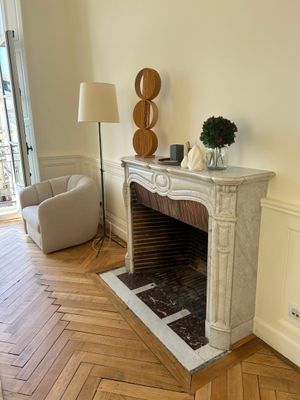 a fireplace in the middle of a room with a lamp on it