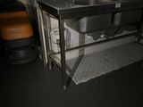 a sink in the corner of a room with a large window