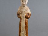 une vieille figurine représentant une femme tenant un livre dans ses mains