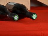 two bottles of wine sitting on a red cloth