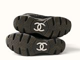pair of black and white shoes with a chanel logo on the sole