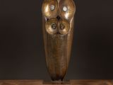 une photo d'une sculpture en bronze posée sur une table en bois