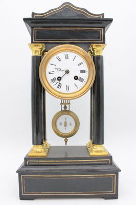 a black and gold clock sitting on top of a table