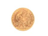 a gold coin with a rooster on it on a white surface
