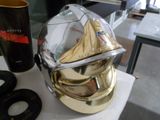 un casque en or posé sur une table, à côté d'une tasse