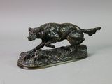 bronze statue of a dog running on a rock on a white background