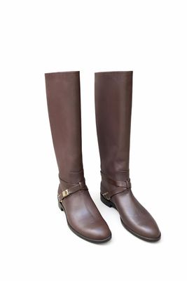 un gros plan sur une paire de bottes marron sur fond blanc