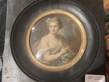 painting of a woman holding a baby in a black frame on a table