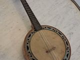 un banjo posé sur une table en marbre, entouré d'une chaîne