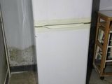 a white refrigerator in the corner of a room