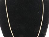 a gold chain necklace on a mannequin neck