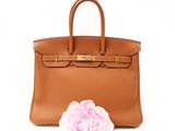 an image of a brown leather handbag with a flower on the side