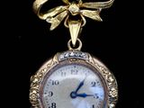 une petite horloge en or ornée d'un nœud
