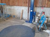 an image of a man standing in a garage with a blue machine