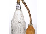 a silver and glass decanter with a brass handle and a glass stopper