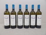 quatre bouteilles de vin sont alignées sur une table