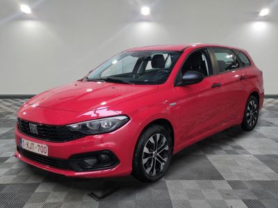 a red car is parked in a room with a checkered floor