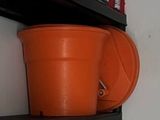 two orange pots on a black shelf in a room
