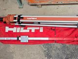 a tripod sitting on a red bag next to a pair of tools