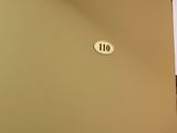 a picture of a room with a door and a sign on the wall