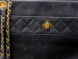 a close up of a black purse with a chain around it