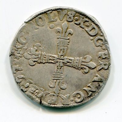 une vieille pièce d'argent sur laquelle figure une croix sur un fond blanc