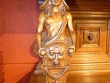 a statue of a woman holding a basket on top of a wooden table