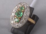 une photo en gros plan d'une bague sertie d'émeraudes et de diamants