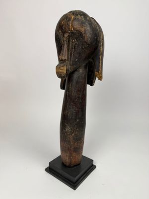 une image représentant une sculpture en bois représentant une tête de femme posée sur un socle noir