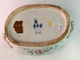 a white bowl with a brown handle and flowers on it