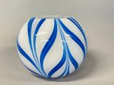 a blue and white striped vase sitting on a table