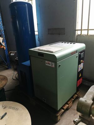 a green machine sitting in a room next to a blue machine