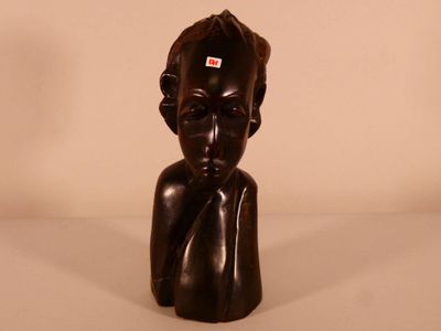 sculpture représentant la tête d'une femme, avec une étiquette rouge sur le front