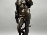 a bronze statue of a man holding a bird on a rock