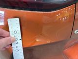 a person holding a ruler next to a car ' s tail light