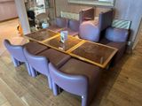 purple leather chairs and a table in a room with a mirror
