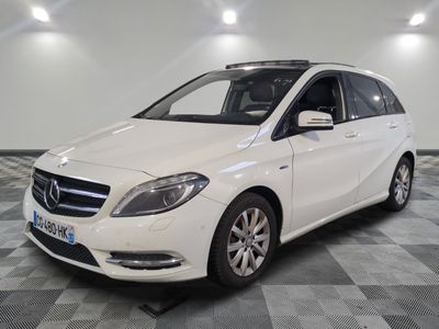 the white mercedes b - class is parked on a checkered floor