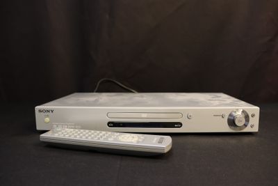 a white sony dvd player and a remote on a table