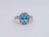 gros plan d'une bague avec une topaze bleue entourée de diamants