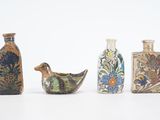 quatre vases différents posés les uns à côté des autres sur une surface blanche