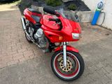 a red motorcycle that is parked on the side of the road