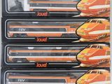 quatre trains miniatures se trouvent dans une boîte posée sur une surface blanche