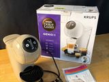 une cafetière posée sur une table à côté d'une boîte de Krups